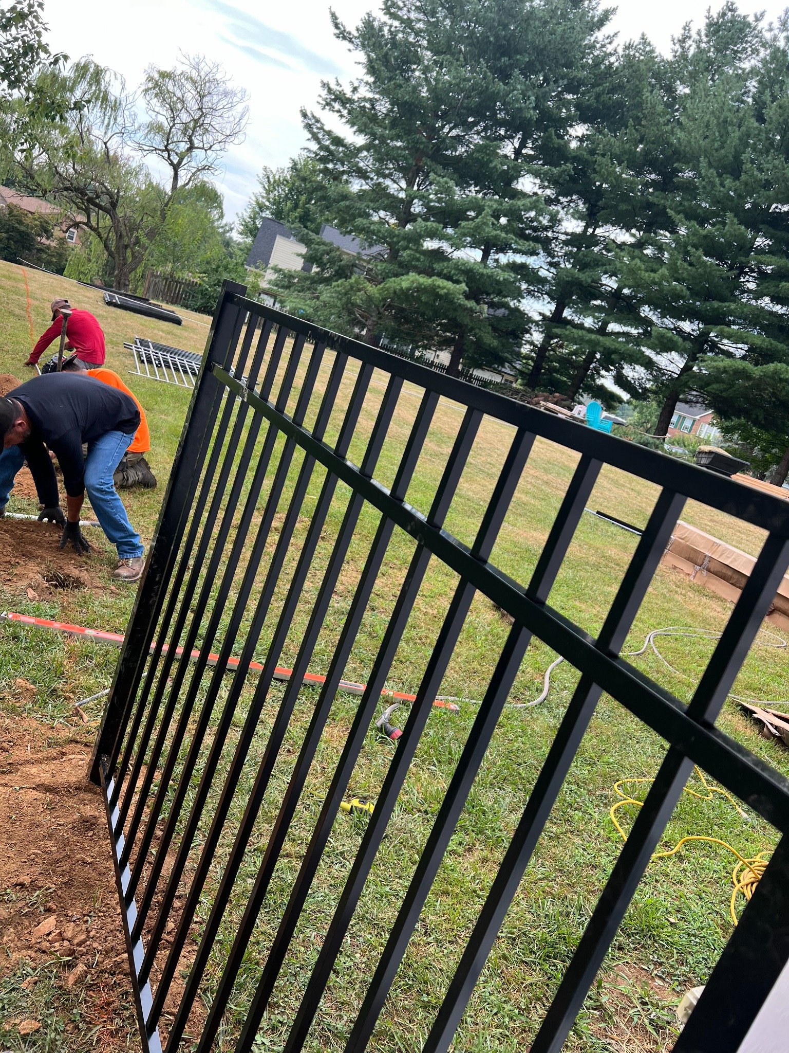 Black metal fence installation in progress