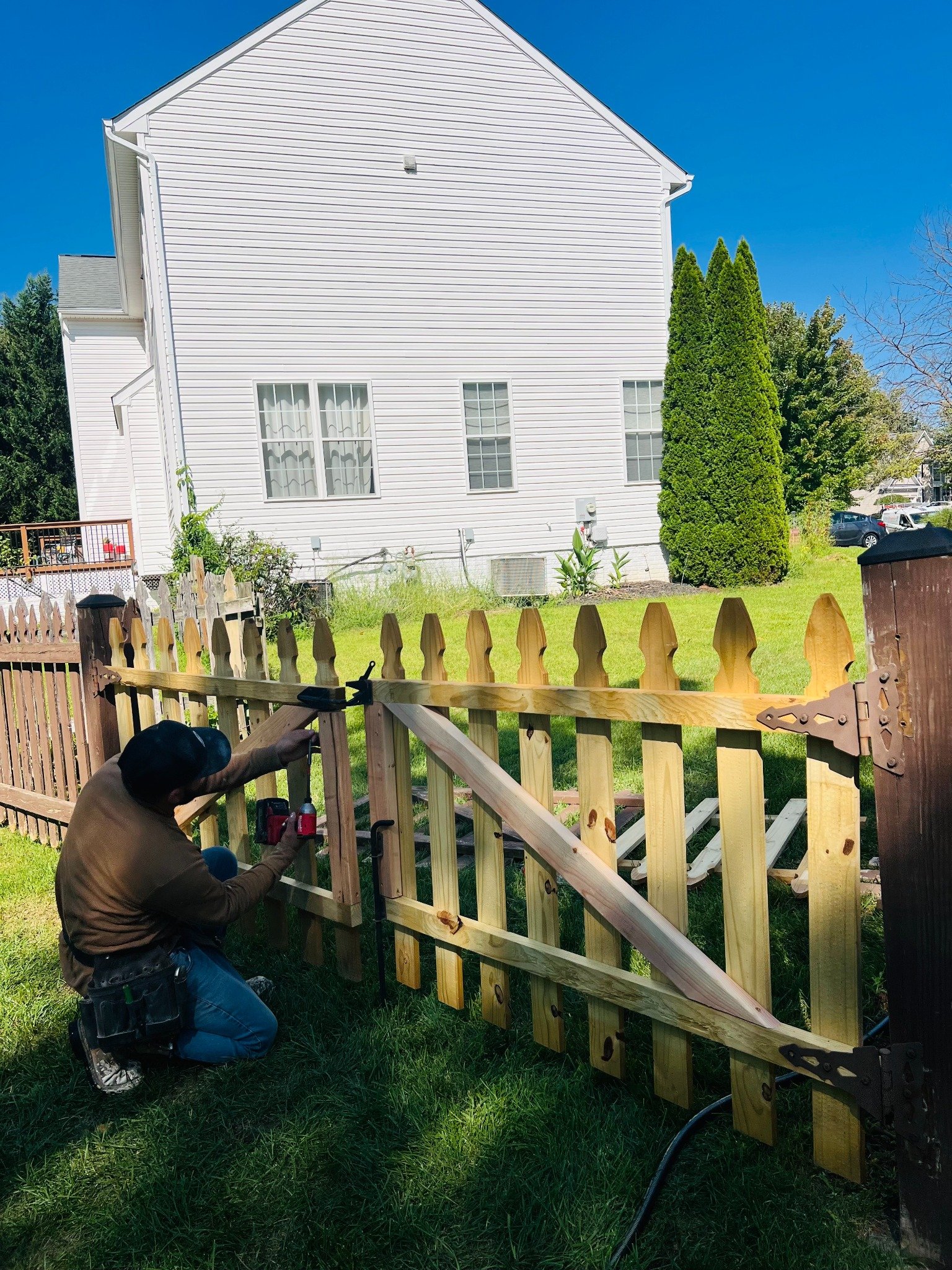 Wood picket gate installation in progress